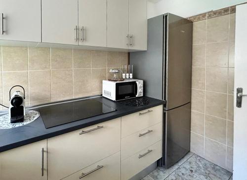 a kitchen with a microwave and a refrigerator at Casa Tranquila in Puerto de la Cruz