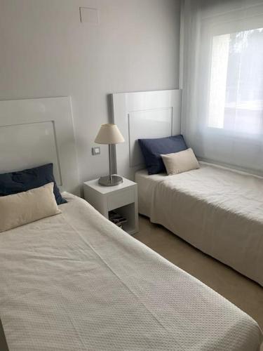 a bedroom with two beds and a lamp on a table at Las Colinas Golf Club Residences Casa Encina 1 in Orihuela Costa