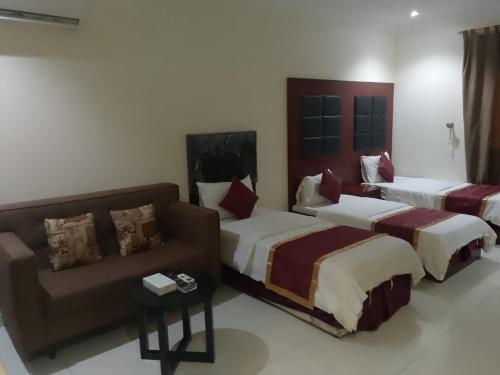 a hotel room with two beds and a couch at أثير-النزهة in Jeddah