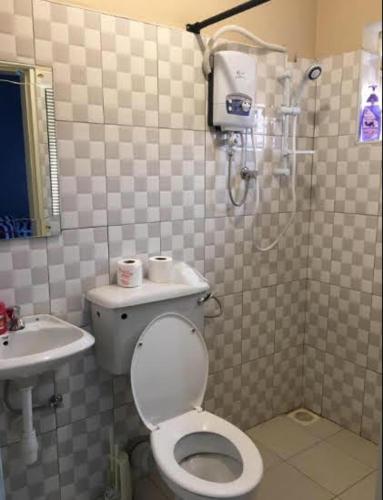 a bathroom with a shower and a toilet and a sink at Tgs Homestay Nest in Kampala