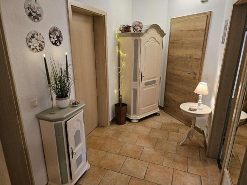 a hallway with a bathroom with a cabinet and a table at fewo-aller-auszeit in Hademstorf