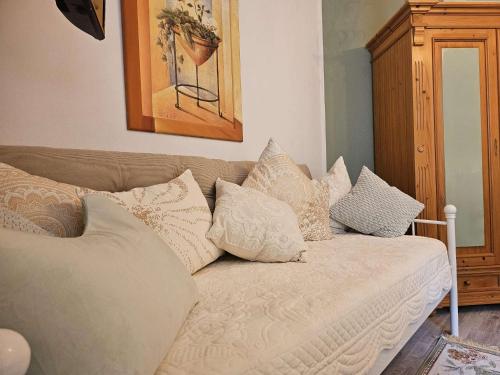 a couch with pillows on it in a living room at fewo-aller-auszeit in Hademstorf