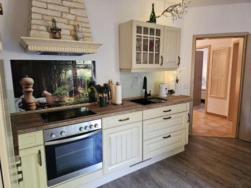 a kitchen with white cabinets and a fish tank at fewo-aller-auszeit in Hademstorf