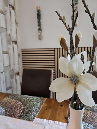 a white flower in a vase on a table at fewo-aller-auszeit in Hademstorf
