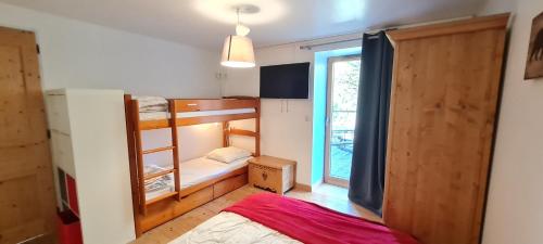 Cette petite chambre comprend des lits superposés et une fenêtre. dans l'établissement CHALET COOP - B - 6 Pers, à Les Deux Alpes
