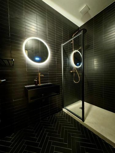 La salle de bains noire est pourvue d'un lavabo et d'une douche. dans l'établissement Luxurious Paris Loft Near Opéra, à Paris