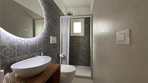a bathroom with a sink and a toilet and a mirror at Casina Carducci Apartment in Nardò