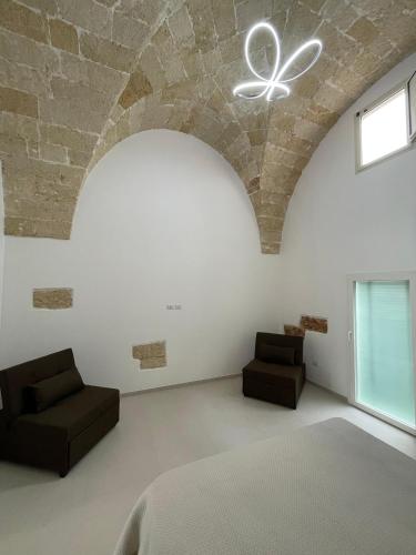 a bedroom with a bed and two chairs at Casina Carducci Apartment in Nardò