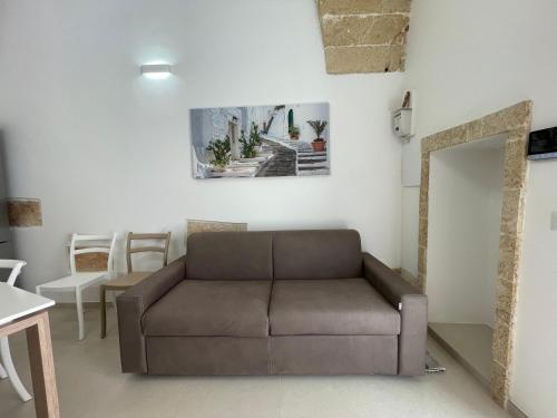 a living room with a brown couch and a table at Casina Carducci Apartment in Nardò