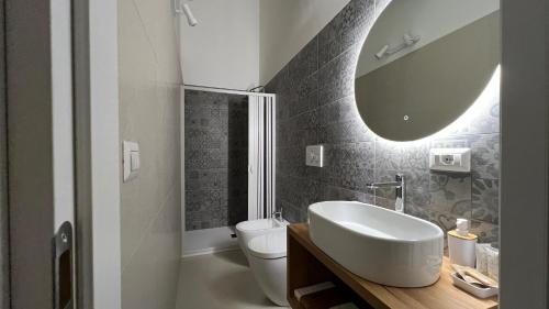 a bathroom with a sink and a toilet and a mirror at Casina Carducci Apartment in Nardò