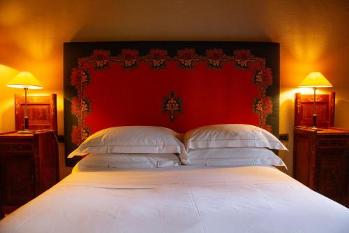 a bedroom with a large bed with a red headboard at Castello Di Tornano Wine Relais in Gaiole in Chianti