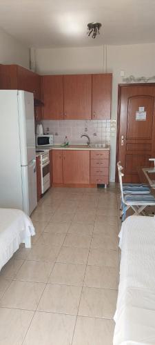 a kitchen with brown cabinets and a white tile floor at Seaside Studios in Paralia Dionysiou