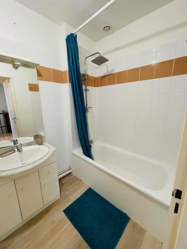 une salle de bain avec une baignoire et un lavabo dans l'établissement Maison de Ville 3 Chambres avec Jardinet et Garage, à Grenade-sur-lʼAdour