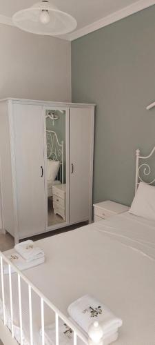 a bedroom with a white bed and a mirror at Seaside Studios in Paralia Dionysiou