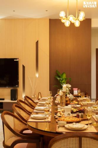 a long table with chairs and food and wine glasses at Middle Earth by Vieda - Part of StayVista with Pool in Karjat