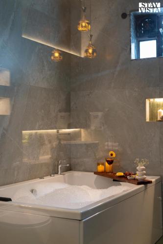 a bathroom with a bath tub and a sink at Middle Earth by Vieda - Part of StayVista with Pool in Karjat
