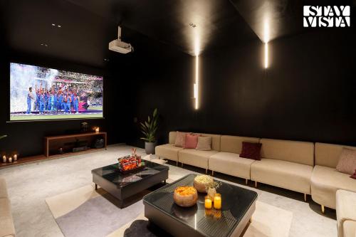 a living room with a couch and a tv at Middle Earth by Vieda - Part of StayVista with Pool in Karjat