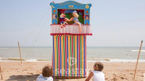 two women sitting on the beach looking at a colorful machine at Aurora Spa Seaview Penthouse Ramsgate in Kent