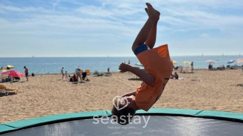 a young girl on top of a trampoline at the beach at Aurora Spa Seaview Penthouse Ramsgate in Kent