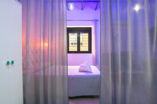 a bedroom with purple curtains and a bed with a teddy bear at Apartamentos Bellamar in Barbate