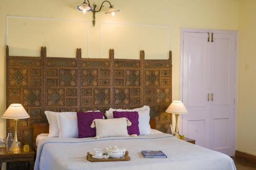 a bedroom with a large bed with purple pillows at Alaya Stays 3 BHK Pet-friendly with Garden - Chalet Vie Villa in Dharampur