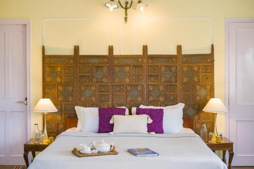 a bedroom with a large bed with purple pillows at Alaya Stays 3 BHK Pet-friendly with Garden - Chalet Vie Villa in Dharampur