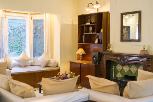 a living room with a fireplace and a couch at Alaya Stays 3 BHK Pet-friendly with Garden - Chalet Vie Villa in Dharampur