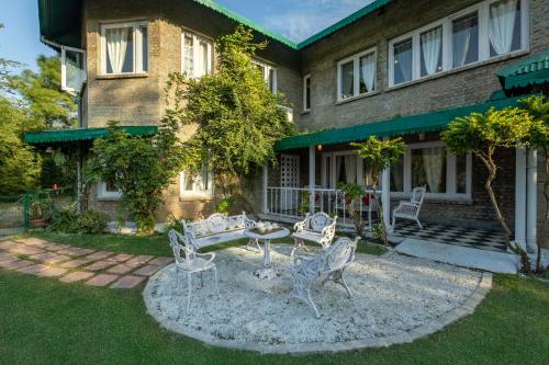 a yard with chairs and a table in front of a building at Alaya Stays 3 BHK Pet-friendly with Garden - Chalet Vie Villa in Dharampur