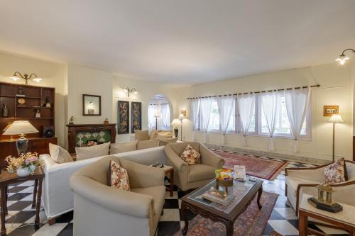 a living room with couches and tables and windows at Alaya Stays 3 BHK Pet-friendly with Garden - Chalet Vie Villa in Dharampur