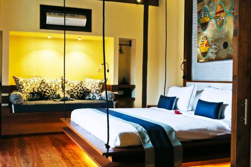 a bedroom with a bed and a couch in it at Kaleydo Villas in Gili Trawangan