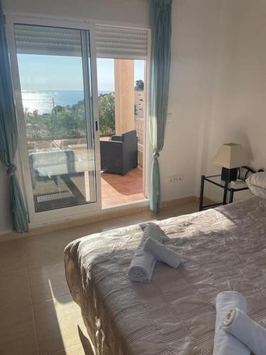 a bedroom with a bed and a view of a balcony at Villa Del Sol in Alicante