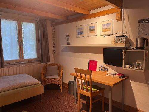 a room with a desk and a bedroom with a bed and a table at Gästezimmer Familie von der Tann in Hannover