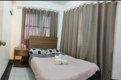 a bedroom with a bed with two white shoes on it at De Hagan Transient Baguio City in Baguio