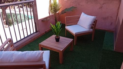 a balcony with two chairs and a table and a plant at Playa Terreros in San Juan de los Terreros