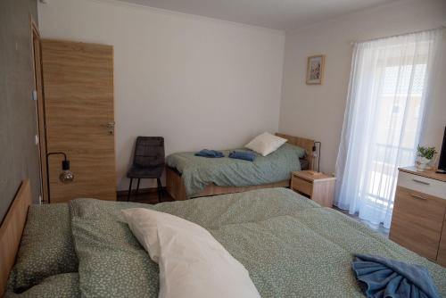 a small bedroom with two beds and a window at Pipi és Papi vendégház in Kiskunlacháza