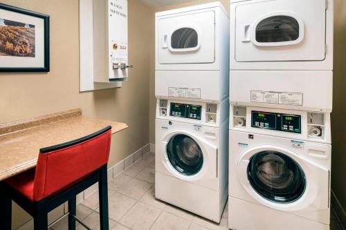 a laundry room with two washer and dryer at Courtyard Milpitas Silicon Valley in Milpitas