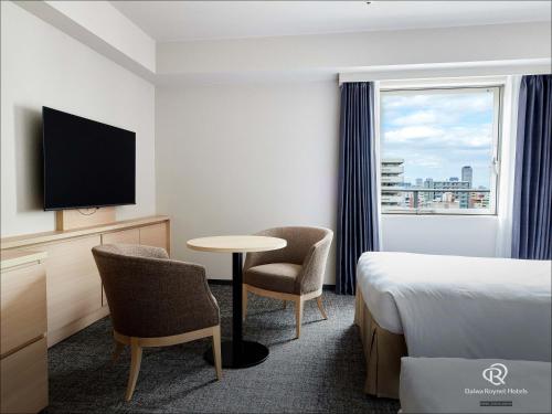 a hotel room with a bed and a table and chairs at Daiwa Roynet Hotel Osaka-Uehonmachi in Osaka
