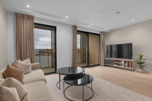 een woonkamer met een bank, een tafel en een tv bij Northstay - The Northview Retreat, Free Parking, Amazing Ocean Views in Tromsø