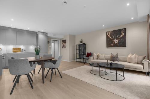 een woonkamer met een bank en een tafel bij Northstay - The Northview Retreat, Free Parking, Amazing Ocean Views in Tromsø