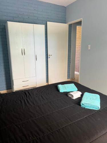 ein Schlafzimmer mit einem Bett mit 2 Handtüchern und Schränken in der Unterkunft Cabaña kaizen in San Rafael