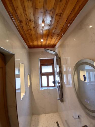 une salle de bain avec un miroir et une fenêtre dans l'établissement Amaris Hotel, à Gjirokastër