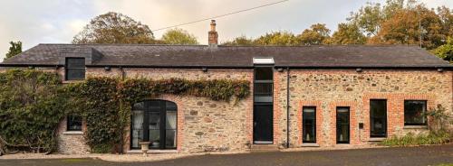 an old brick building with ivy growing on it at The Barn, Walworth Demesne in Ballykelly