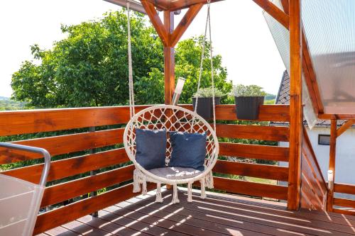 a porch swing with two blue pillows on it at CsillaG Apartman in Kisapáti