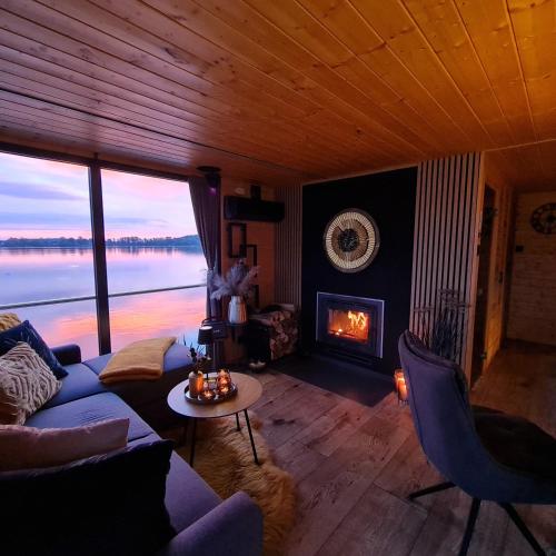 a living room with a couch and a fireplace at Seezeit- Schwielochsee- Hausboot in Schwielochsee