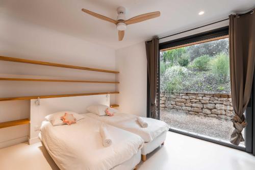 deux lits dans une chambre avec une grande fenêtre dans l'établissement Superbe maison 234 m² avec piscine chauffée, à Saint-Didier-au-Mont-dʼOr