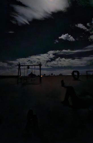 a group of people sitting on the beach at night at Berber Merzouga Luxury Camp in Merzouga