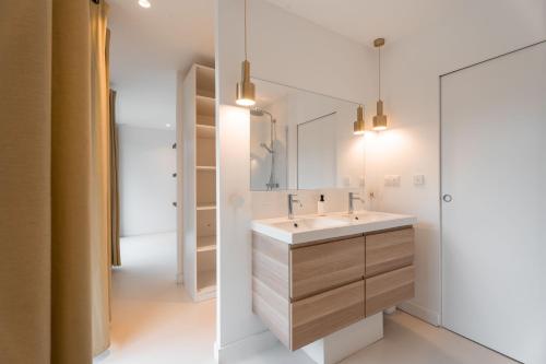 une salle de bain avec un lavabo et un miroir dans l'établissement Superbe maison 234 m² avec piscine chauffée, à Saint-Didier-au-Mont-dʼOr