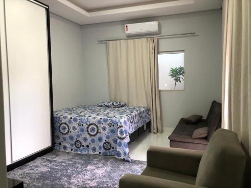 ein Wohnzimmer mit einem Bett und einem Spiegel in der Unterkunft Sua casa fora de casa, ao lado do shopping in Jacuda