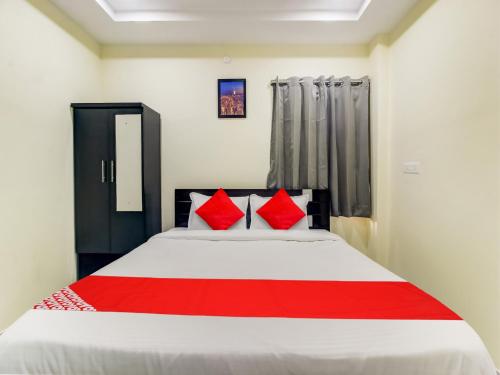 a bedroom with a large bed with red pillows at Super Hotel O SRI NIRVANA PRIDE in Hyderabad