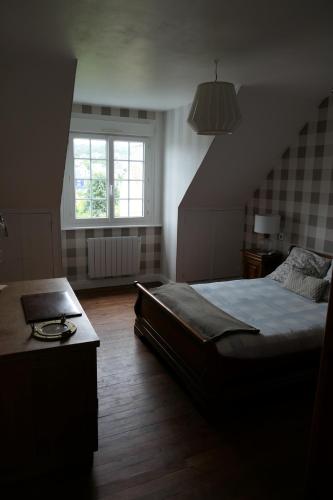 une chambre avec un grand lit et une fenêtre dans l'établissement maison 3 chambres spa centre Morgat, les plages et les restaurants a pied, à Crozon